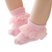 Pink baby socks with lace details on a white background