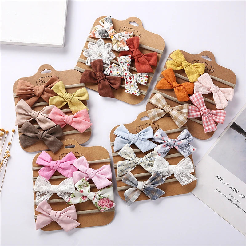 Set of colorful hair bows on wooden stands against a white background