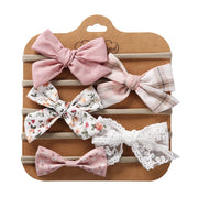 Set of decorative hair bows on a brown card with a clear background