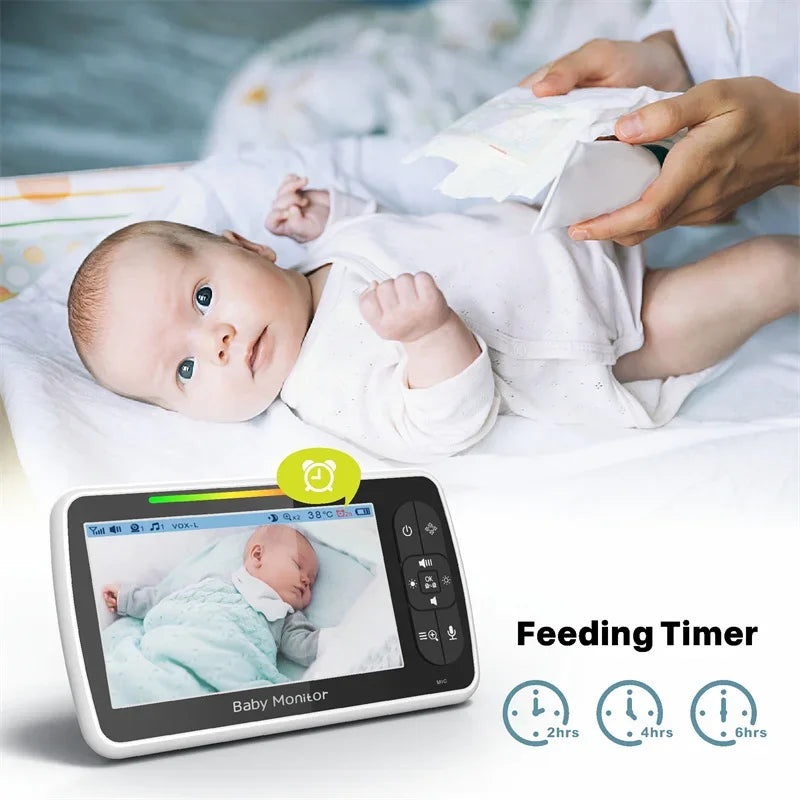 Baby lying on a bed with a baby monitor displaying the baby's video feed, showing a 'Feeding Timer' feature.